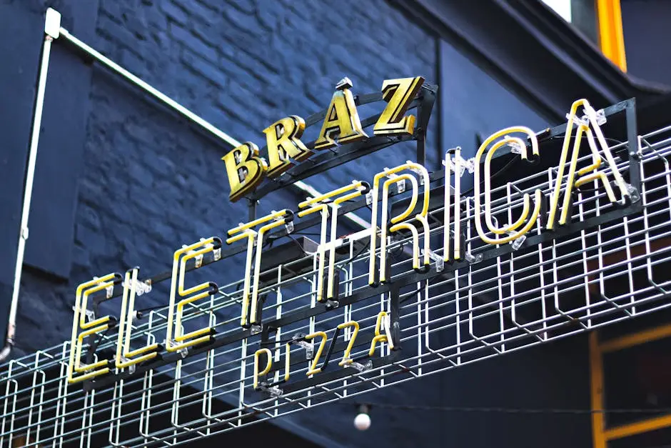 A vibrant neon sign displaying 'Elettrica' at a pizza restaurant, captured outdoors with a striking low angle.