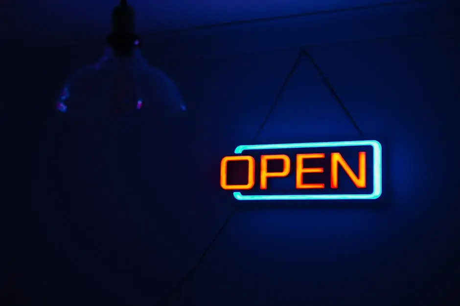 Brightly lit 'Open' neon sign against a dark background, creating a vibrant and inviting atmosphere.