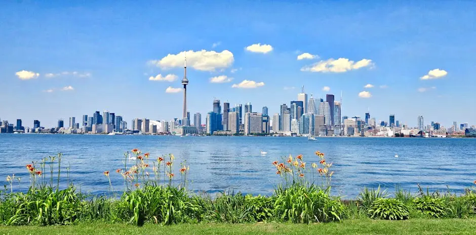 Scenic view of Toronto skyline with CN Tower against a clear blue sky, seen from across the waterfront.